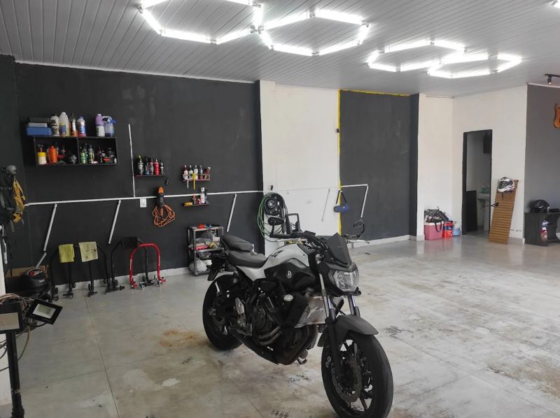 Moto na oficina ao lado de bancada de produtos